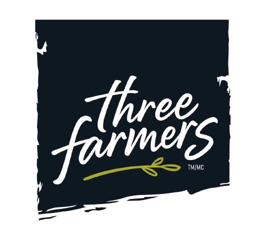 The Three Farmers logo shows white handwritten text on a dark brushstroke background with a small green sprig underneath, symbolizing natural origins.