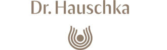 The Dr. Hauschka logo shows the brand name above a curved emblem with a central dot, symbolizing balance, care, and natural harmony.
