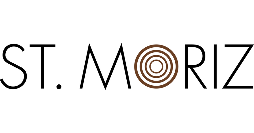 The St. Moriz logo features the brand name in sleek black uppercase letters, with the “O” replaced by concentric brown circles symbolizing a radiant, sun-kissed glow.
