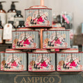 Pyramid retail display of six Barefoot Venus Ruby Red cocoa butter bath soak tins on a dark wooden surface.
